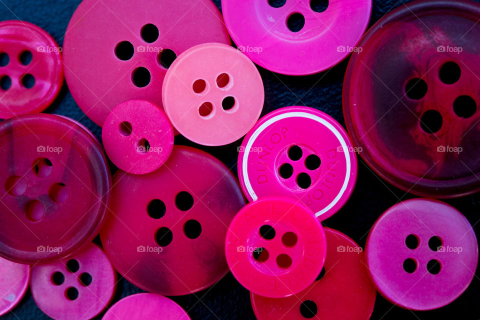 Pink - image of different pink buttons close up on black surface