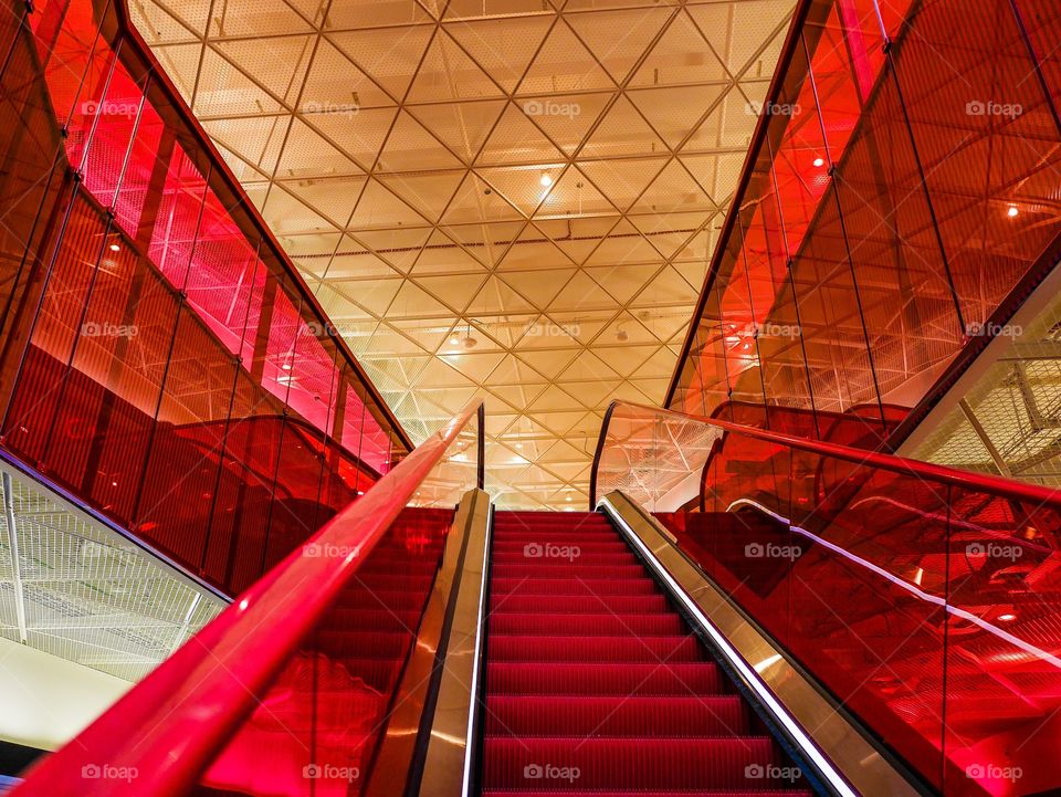 Red plastic and glass interior with an escalatior in the middle