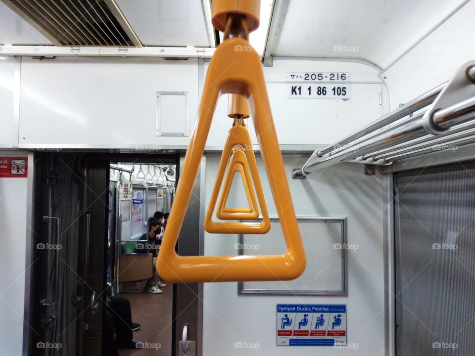 Orange triangular hand grip in commuter trains