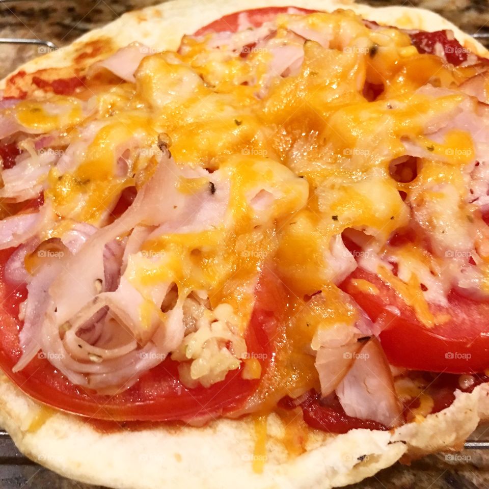 Delicious homemade garlic olive oil, Shallots, Organic tomatoes, ham and cheese pizza made with a flour tortilla