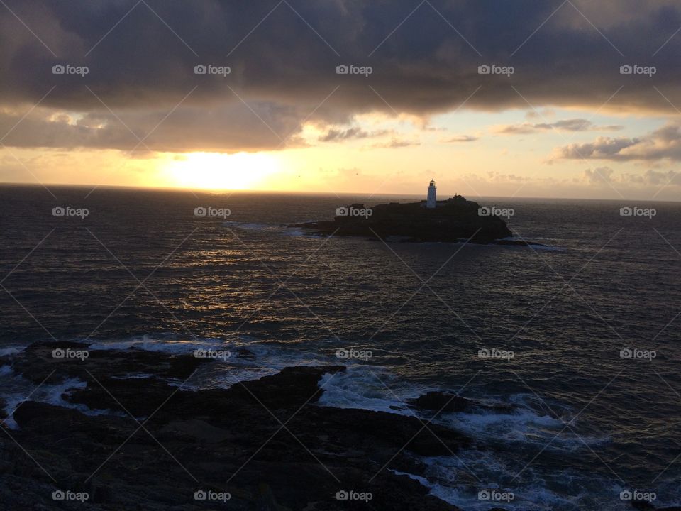 Lighthouse on island at sundown 