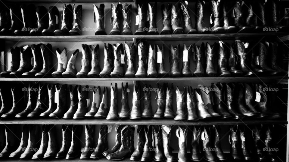 Prateleira com muitas botas masculinas de couros legítimos em loja country.