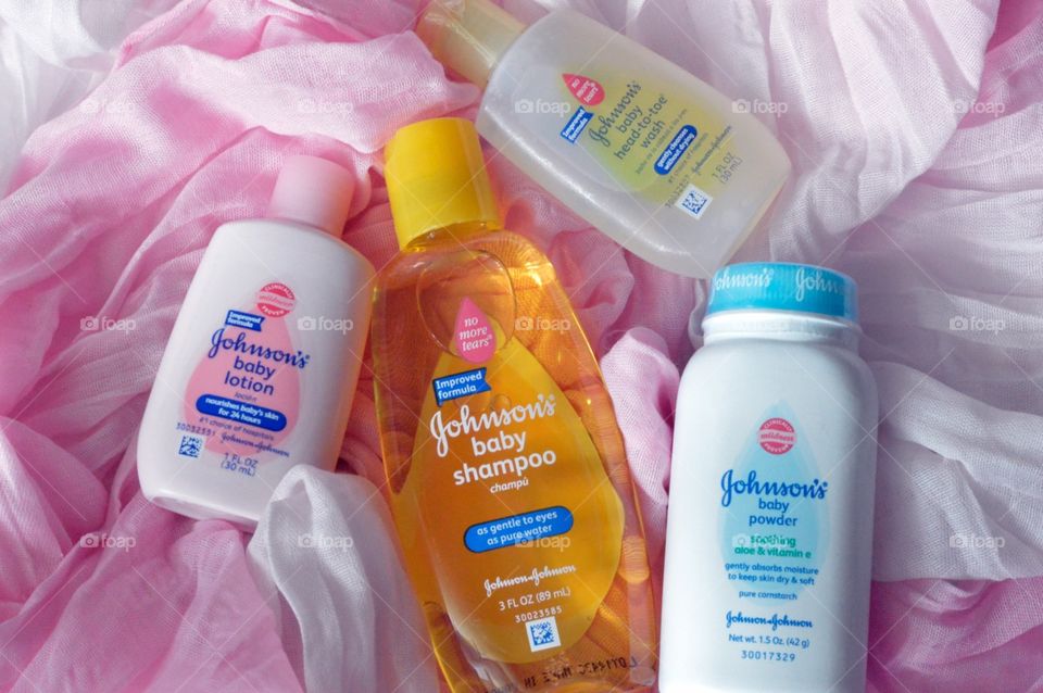 Johnson and Johnson baby products on a pink background flat lay 