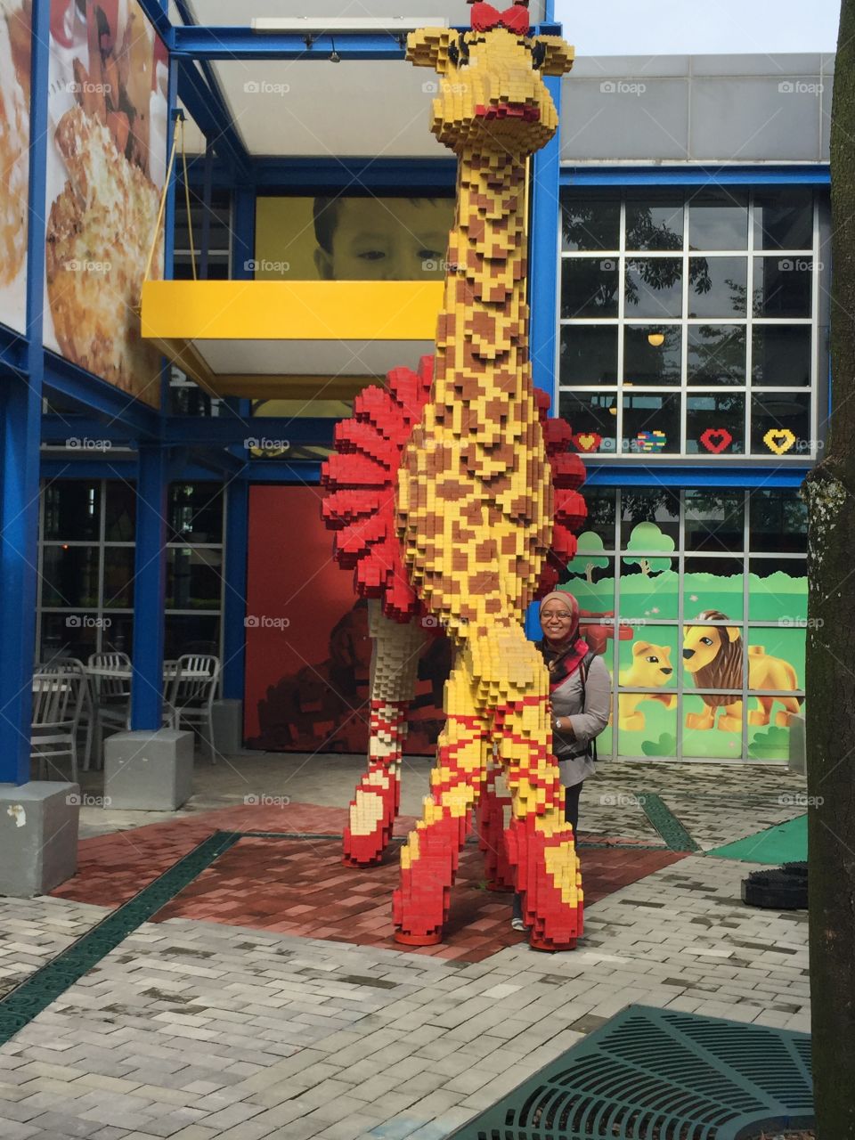 Woman standing near big sculpture of giraffe