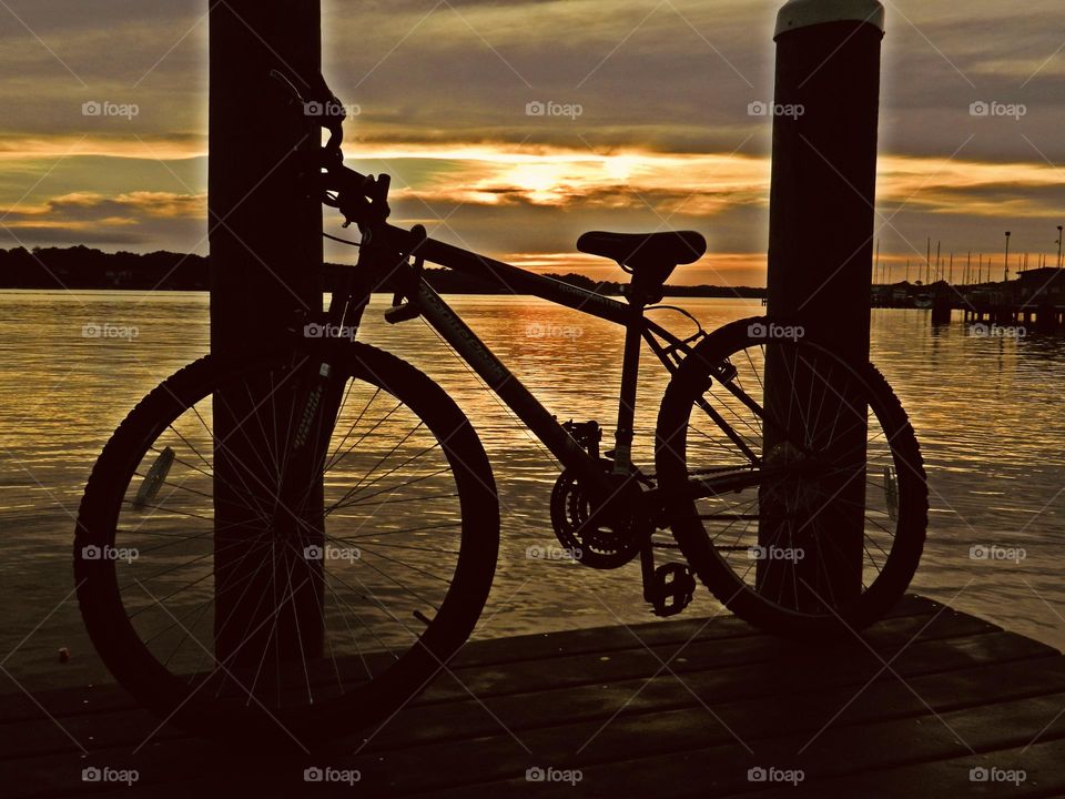 Bicycles are best - Riding into the sunset - Silhouette of a bicycle on the dock during a magnificent sunset 