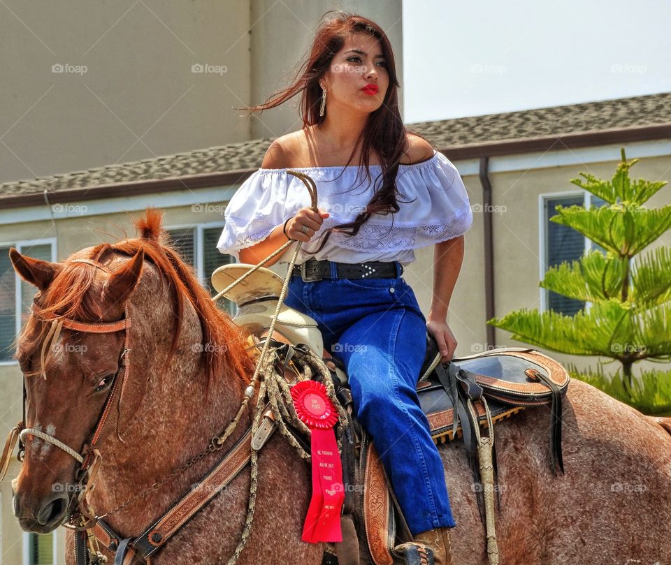 Cowgirl In The Golden Hour. Western Cowgirl Riding Her Prize Horse Before Sundown
