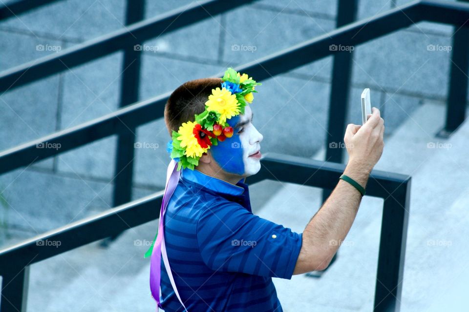 A football fan is taking photos by mobile phone