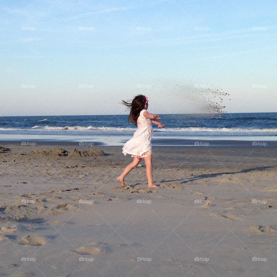 Dancing in the sand . Using her imagination caught up in the moment 