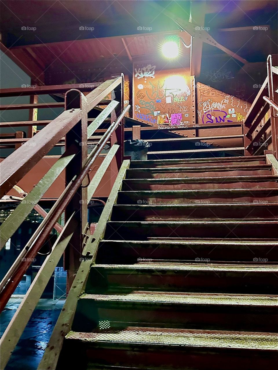 This is the illuminated red metal staircase that leads to the pedestrian lane of the “Pulaski Bridge” in “Greenpoint”, Brooklyn. The bridge leads to LIC, Queens and our boat at “Newtown Creek”. 2023. Hypnotic Productions