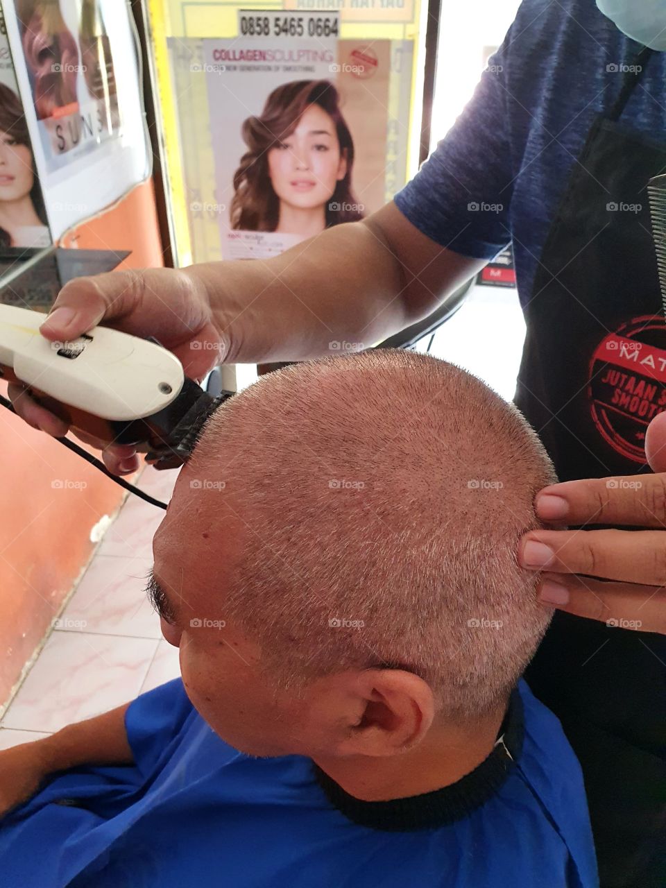 The process of shaving a man's hair into bald with a razor at the barber