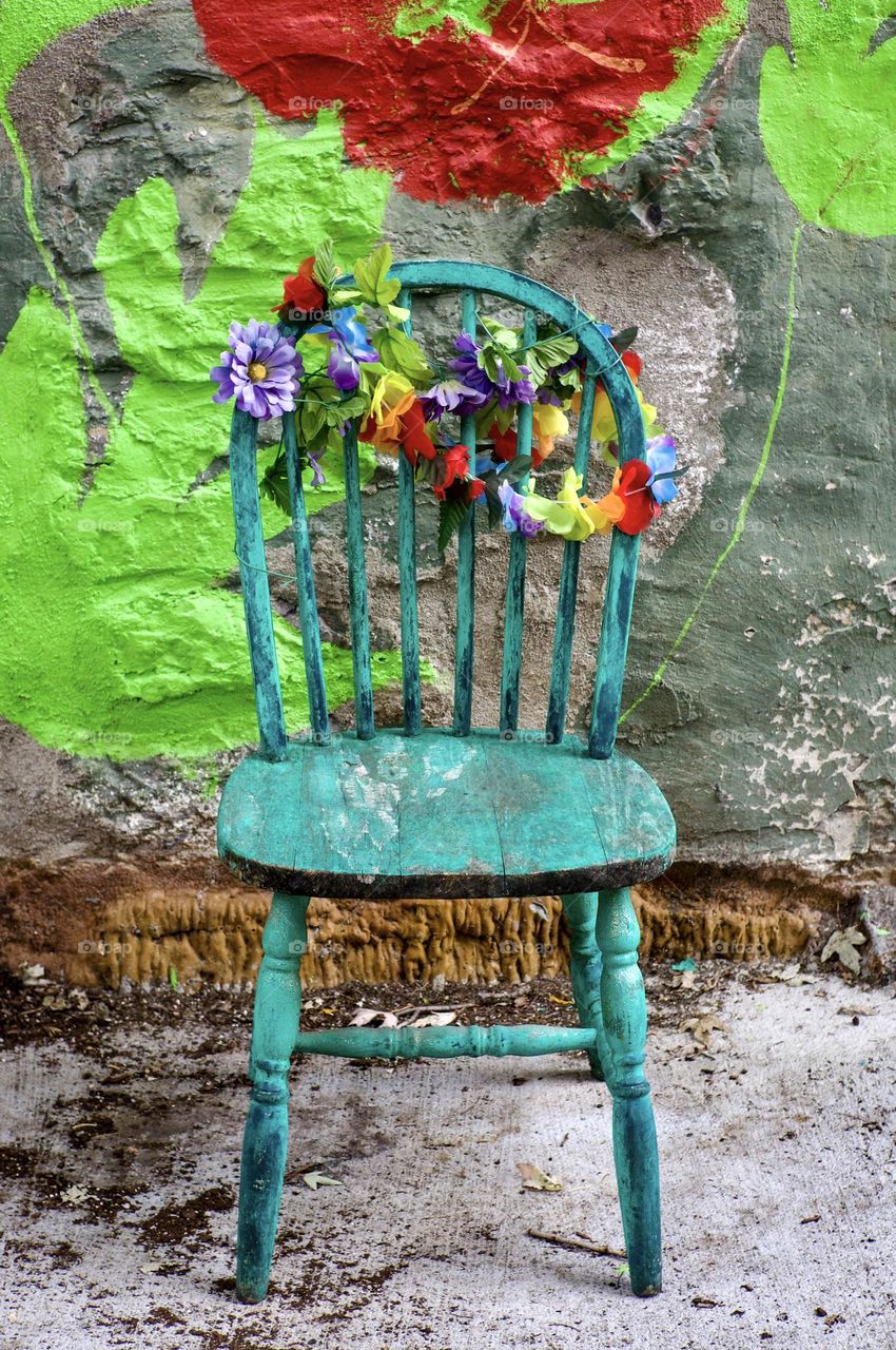 Antique wooden chair adorned with artificial flowers.