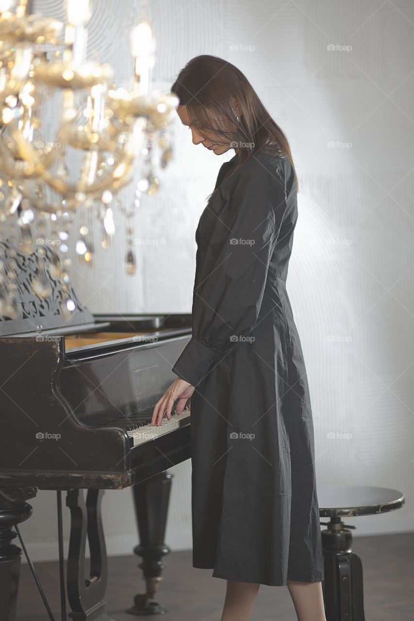 Woman in black dress at the piano, style, art