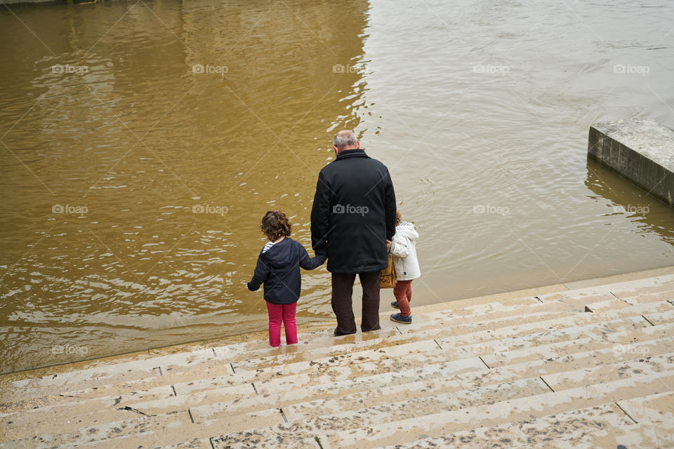 Grandfather and grandsons looking at the  Siene  flood