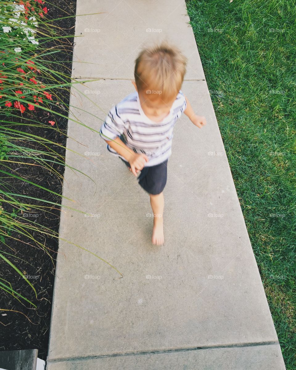 Child running. Child running down sidewalk, playing tag