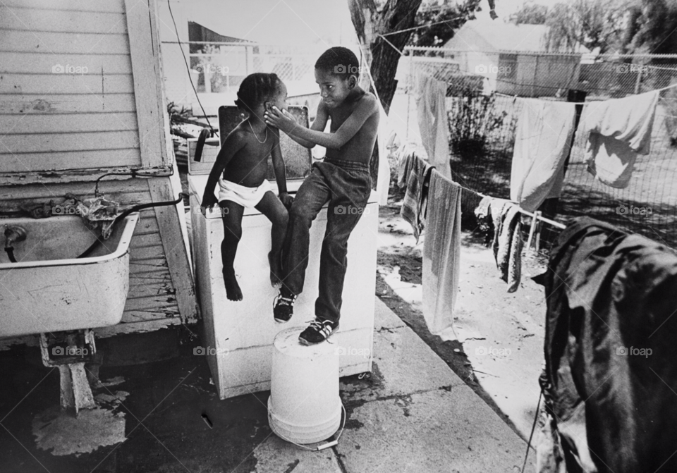 brother and sister in their backyard. poverty stricken family. poverty in usa. by arizphotog