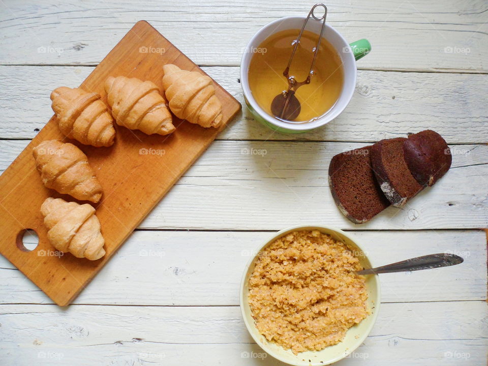 corn porridge, croissants, bread and a cup of green tea