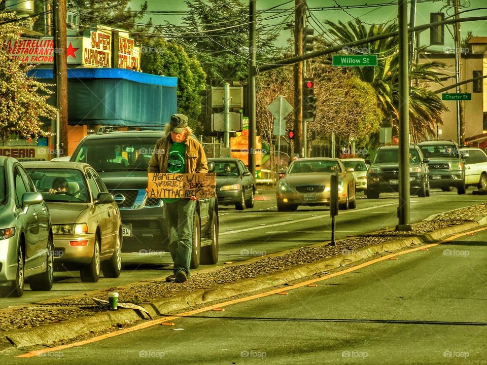 Homeless Man At A Busy Intersection
