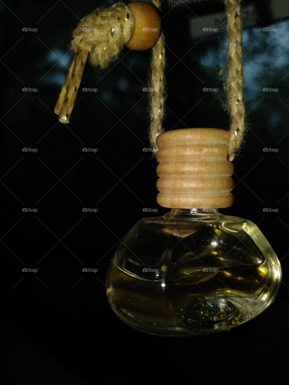 car freshener bottle hanging on the car mirror for fresh air it's looking good also antique to see