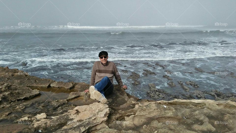 I m sitting on rock near the sea