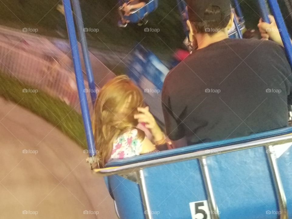 daughter and dad swinging on swing ride