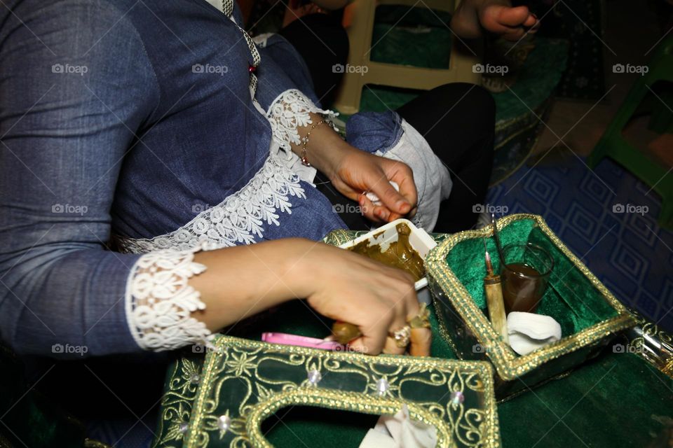 Decorating the bride with henna