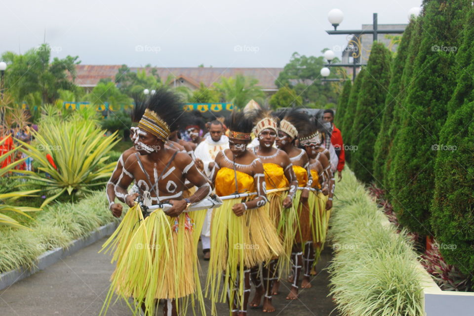 Boys and girls of Kamoro tribe use traditional clothing and dance