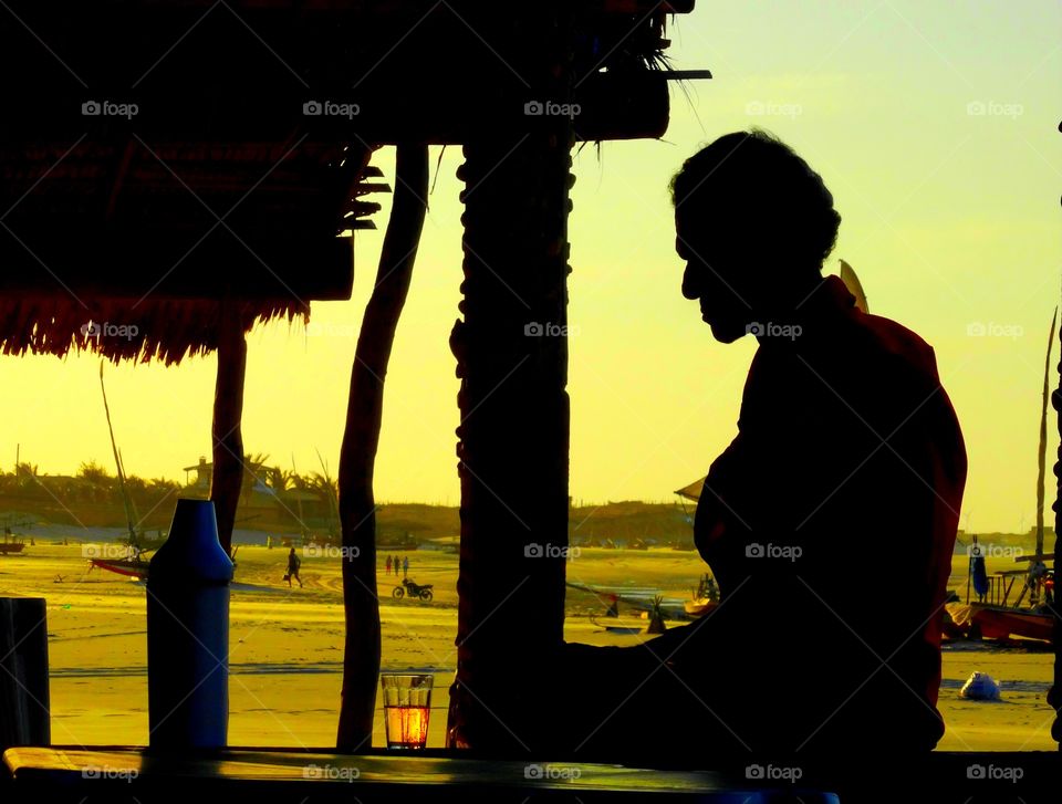 A lonely man at the beach. A man drinking beer at the beach. He looked  sad and lonely