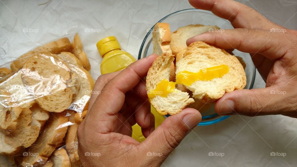 Person's hand holding bread with sauces
