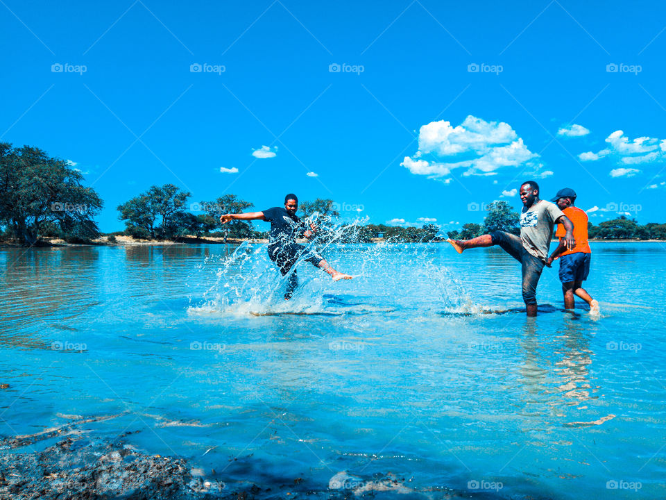 men out in the water having a blast in the sun