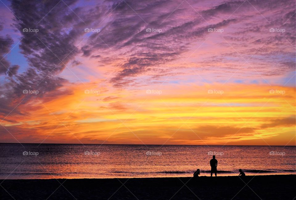 Beautiful Siesta Key Sunset with  a silhouette of a family on the beach 