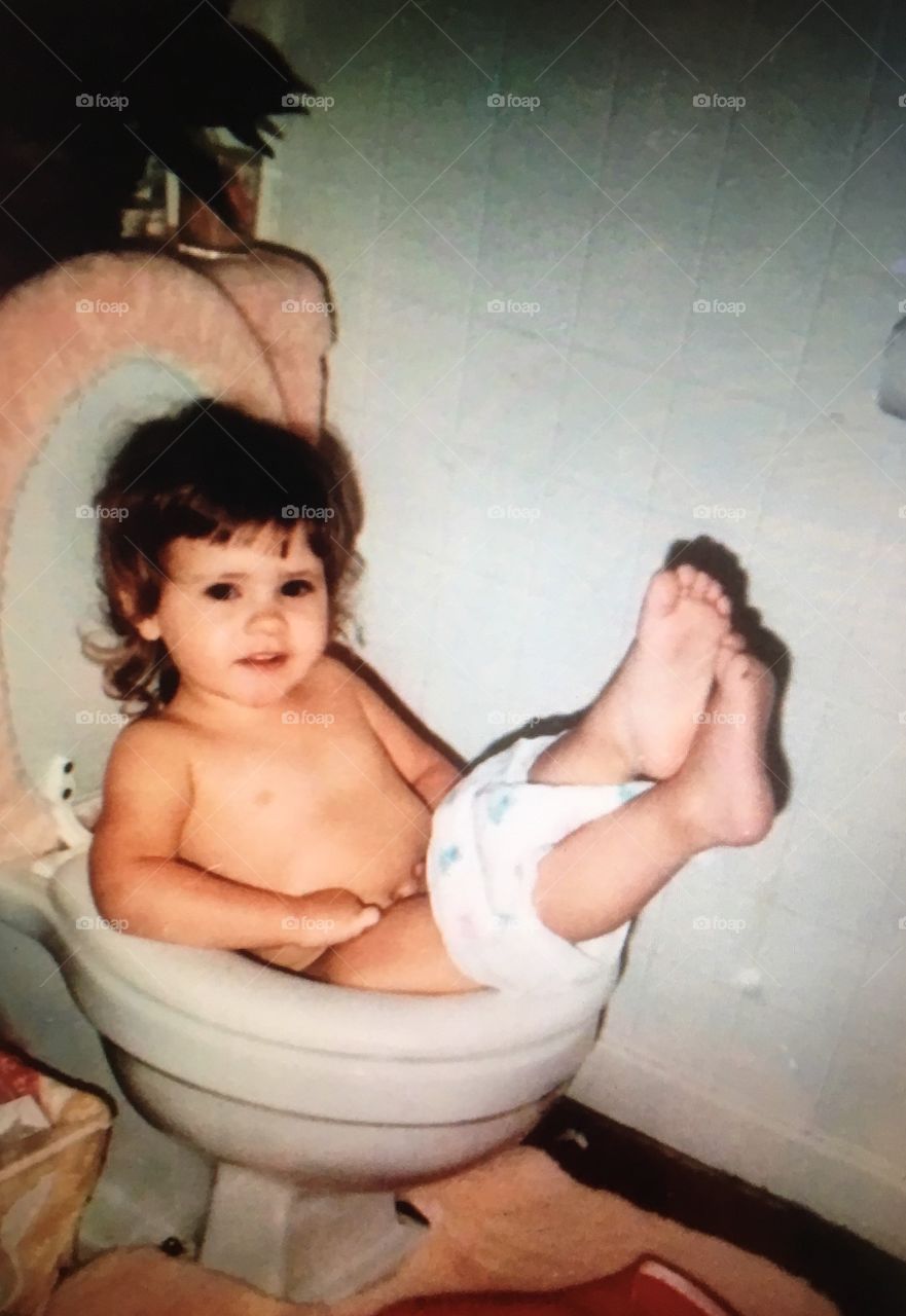 Little girl sitting on toilet seat
