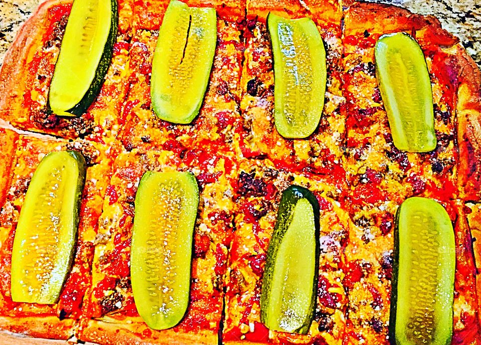 Cheeseburger Pizza with pickle garnish 