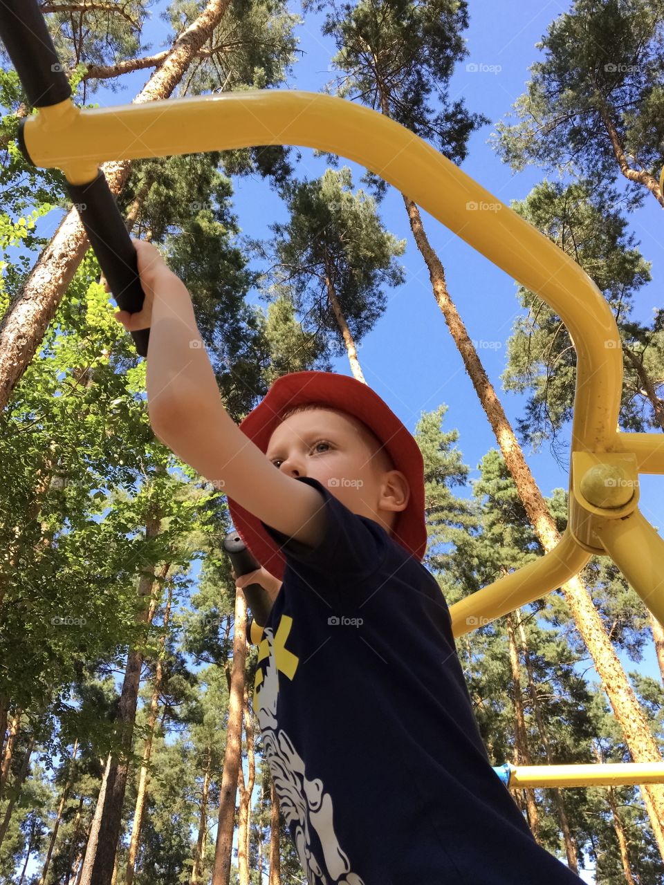 the boy goes in for sports on a metal sports ground in park