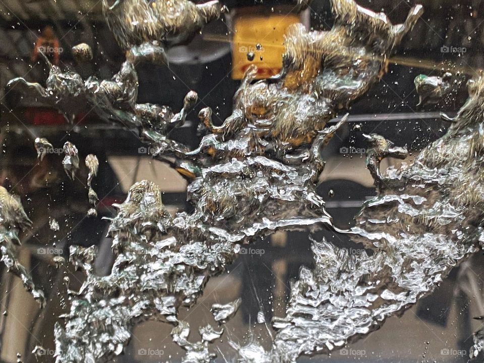 Water being blown off a windshield in a car wash