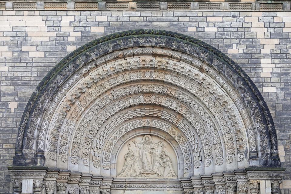 Jesus Christ blesses to Saint Cyril and Methodius. Neo-romanesque portal of old Saint Cyril and Methodius Church in Karlin, Prague, Czech Republic. 