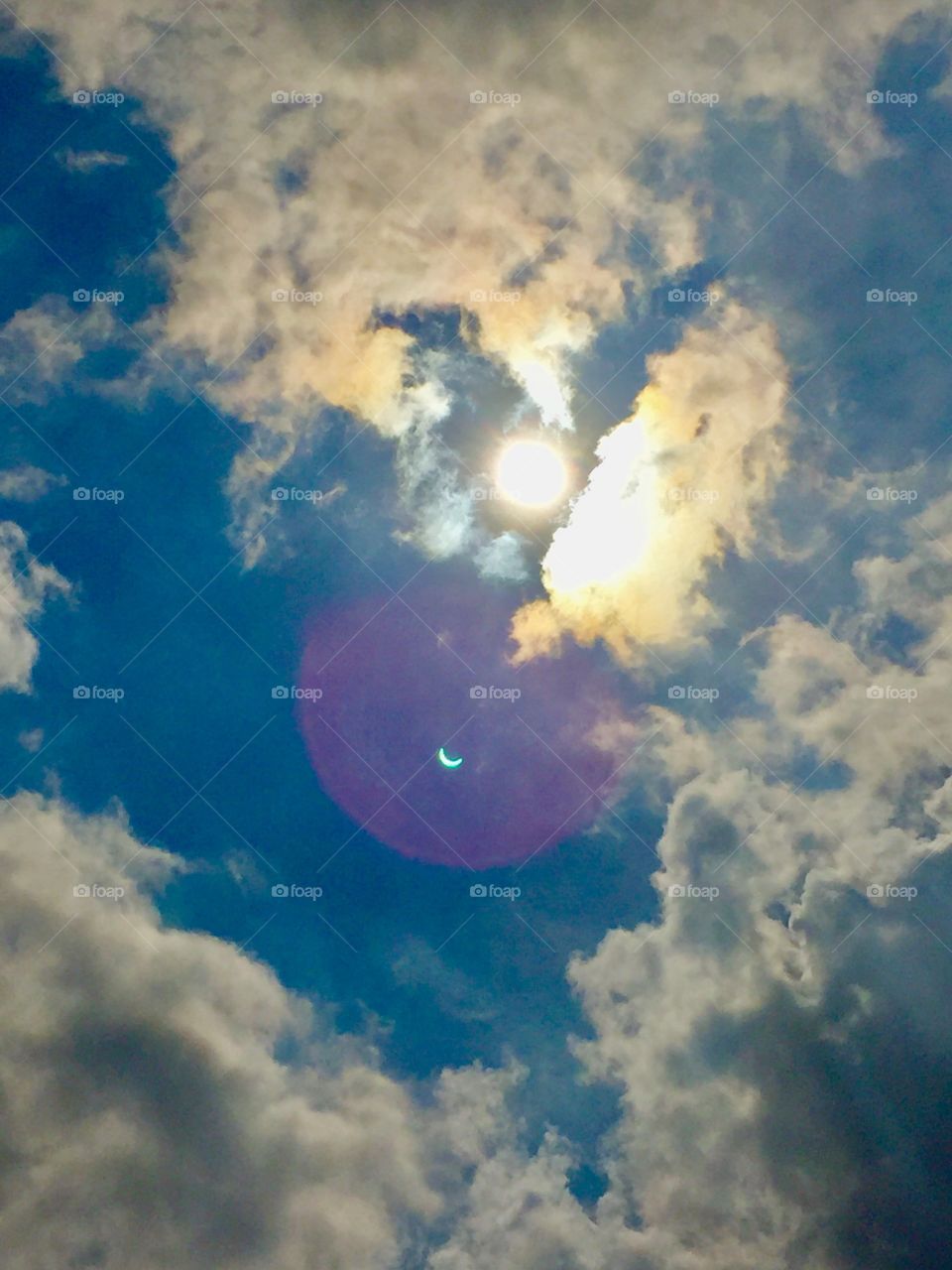 Heavenly eclipse of the sun peeking through the clouds on a summer day