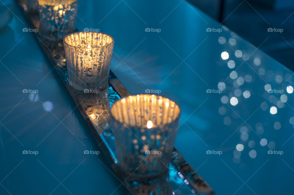 Sparking candlelight on holiday party for Christmas or New Year’s Background with blue Sparkling light