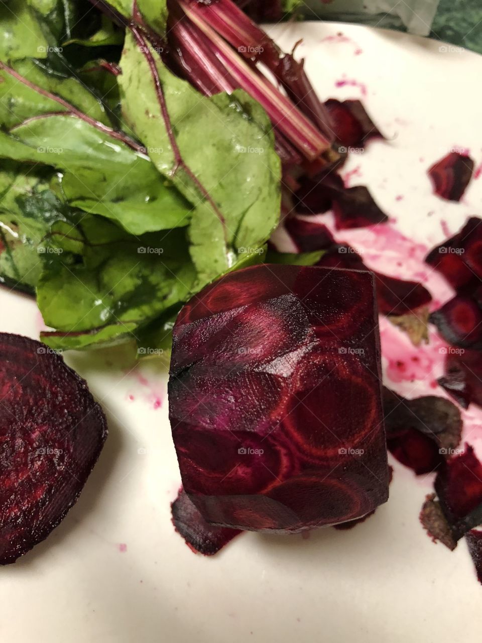 Beautiful deep red maroon beets and beet greens, peeled and ready to cook. 