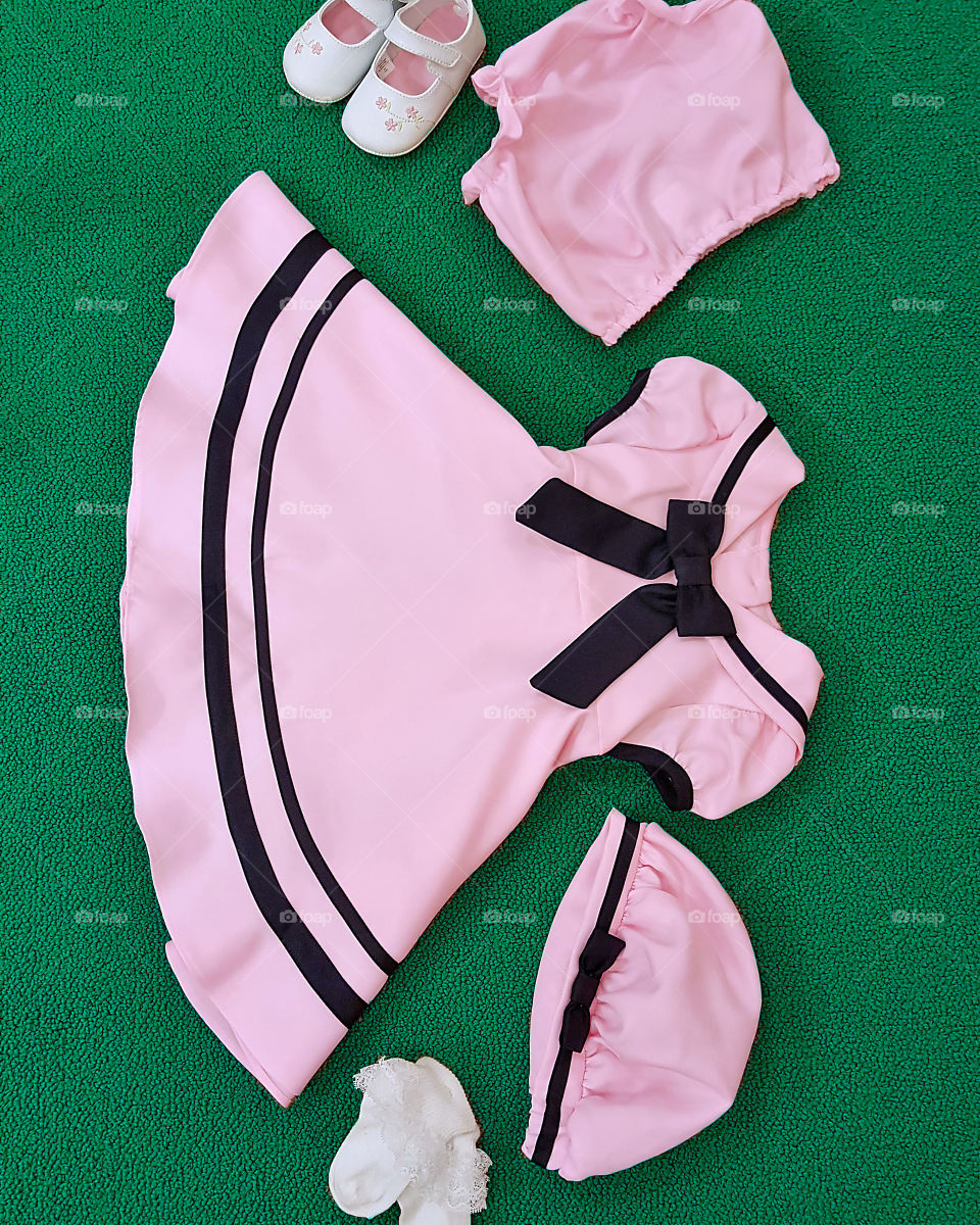 baby girl fashion flat lay / layout featuring a pink and navy sailor dress.