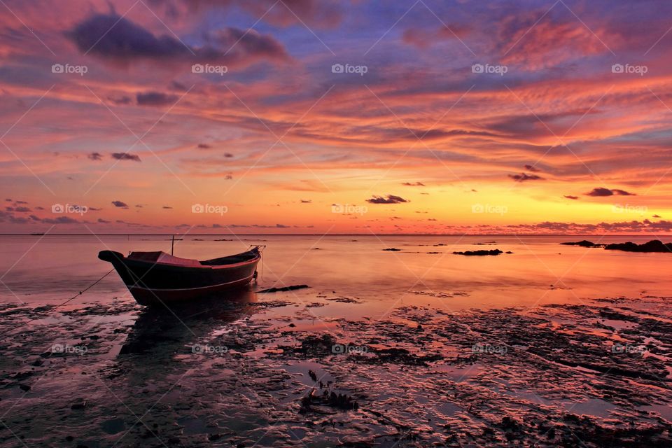 Alone boat under sunset at Tanjung Dewa Beach, South Kalimantan, Indonesia.