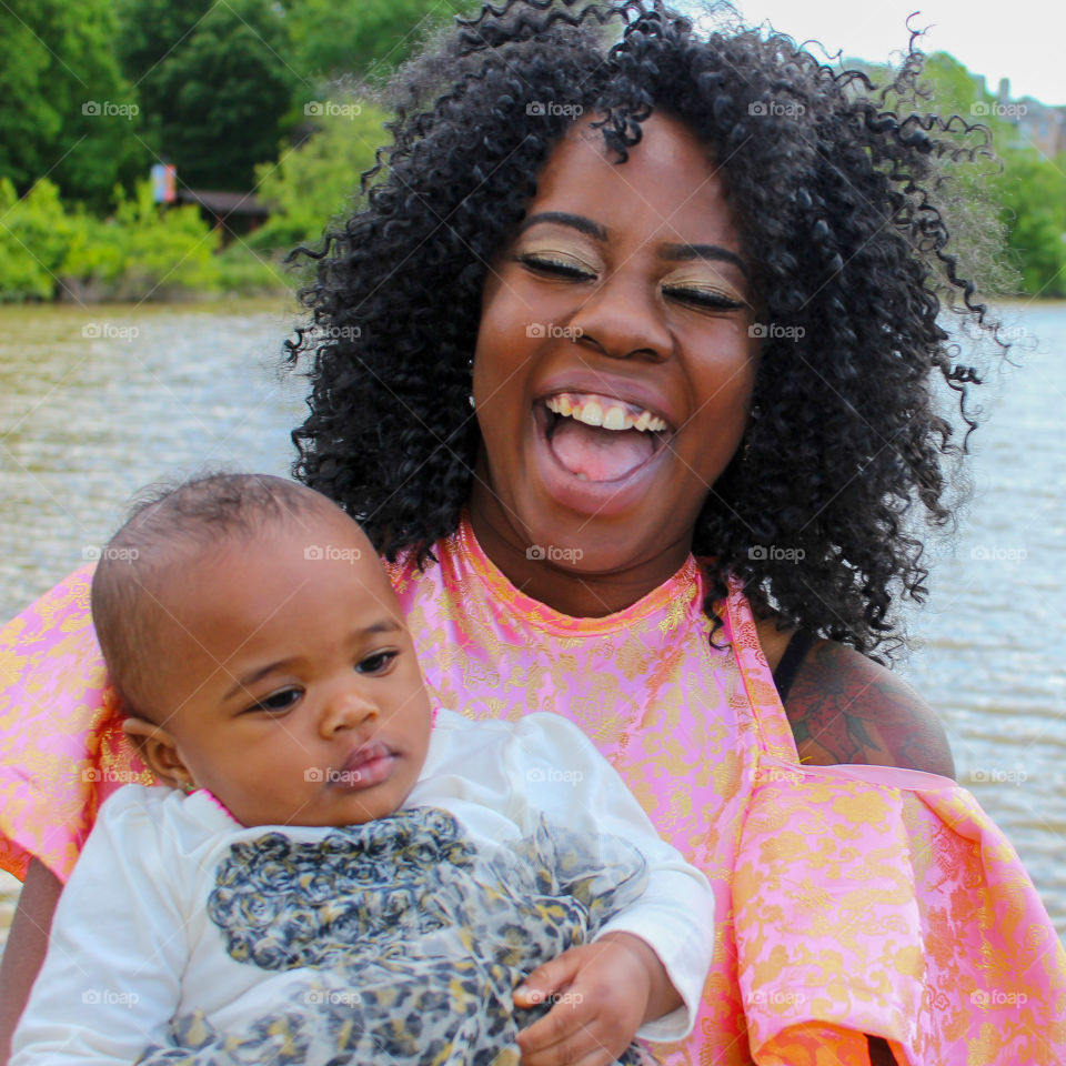 Woman laughing while holding infant