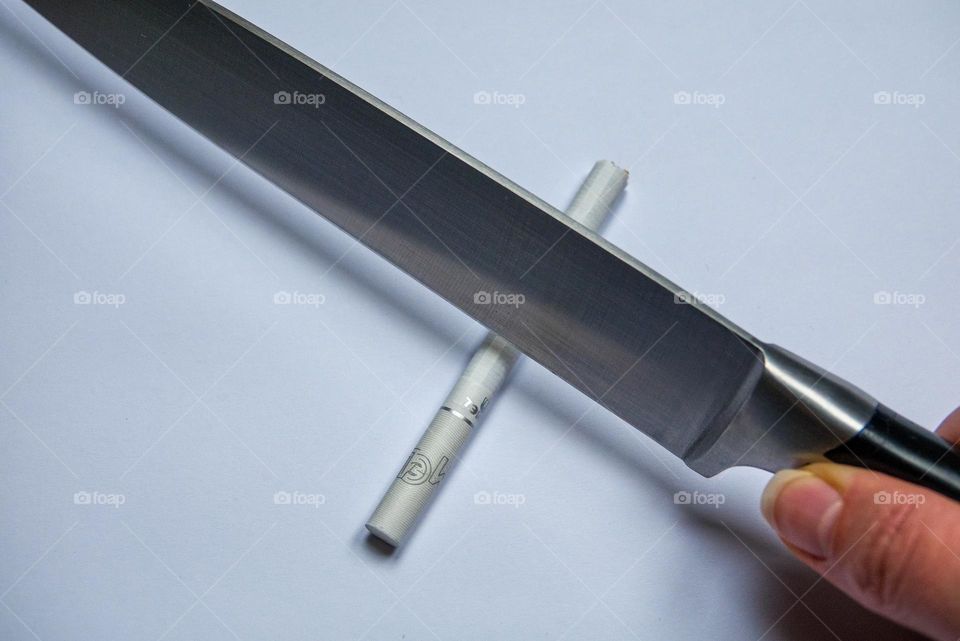 New Year's resolutions to quit smoking. Cigarette and knife.