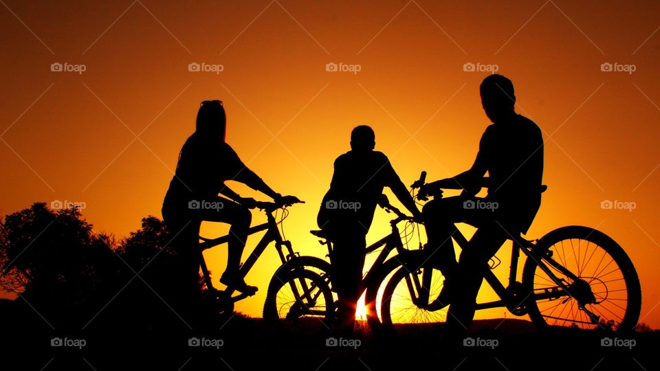 Silhouette of people with bicycle