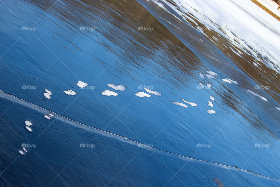 Snowy Footprints Across A Frozen Pond