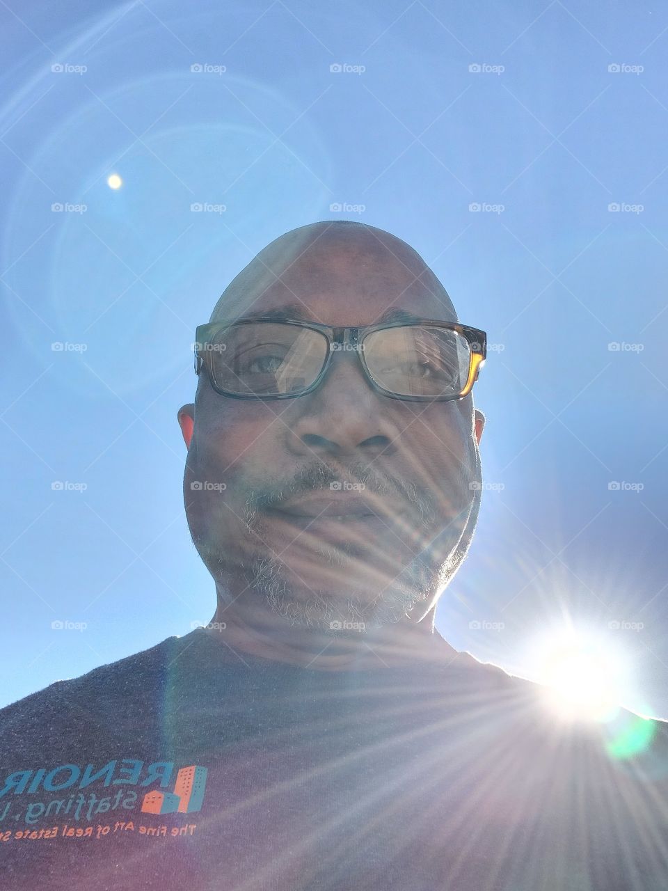 sunlight lens flare of a self portrait of a man wearing glasses