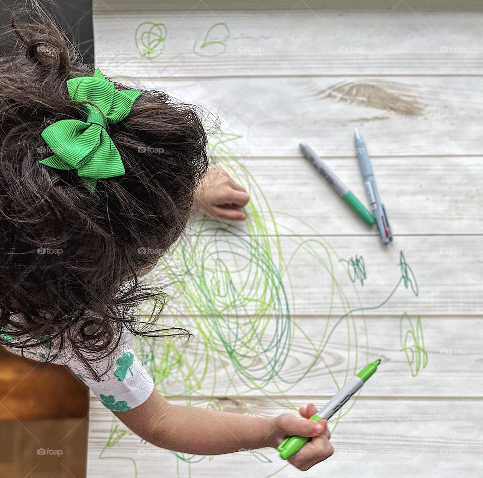 Toddler girl creating art, toddler sits at table drawing with markers, toddler girl makes art, green circle art with toddler, toddler using Sharpie markers, creating a masterpiece, St. Patrick’s Day Art being created by a toddler, fun with markers