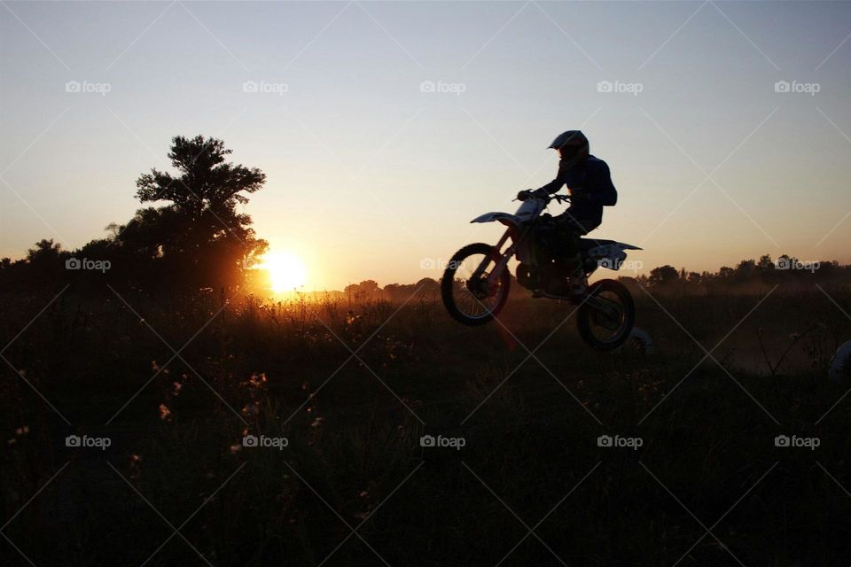 Boy ride motorcycle on sunset