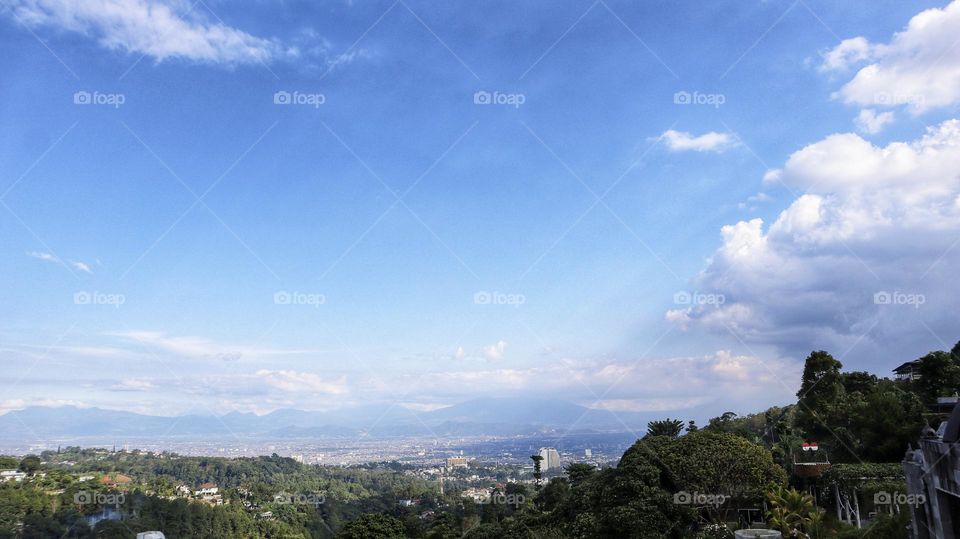 Landscape natural scenery of tropical mountains and residential residential areas with blue skies.