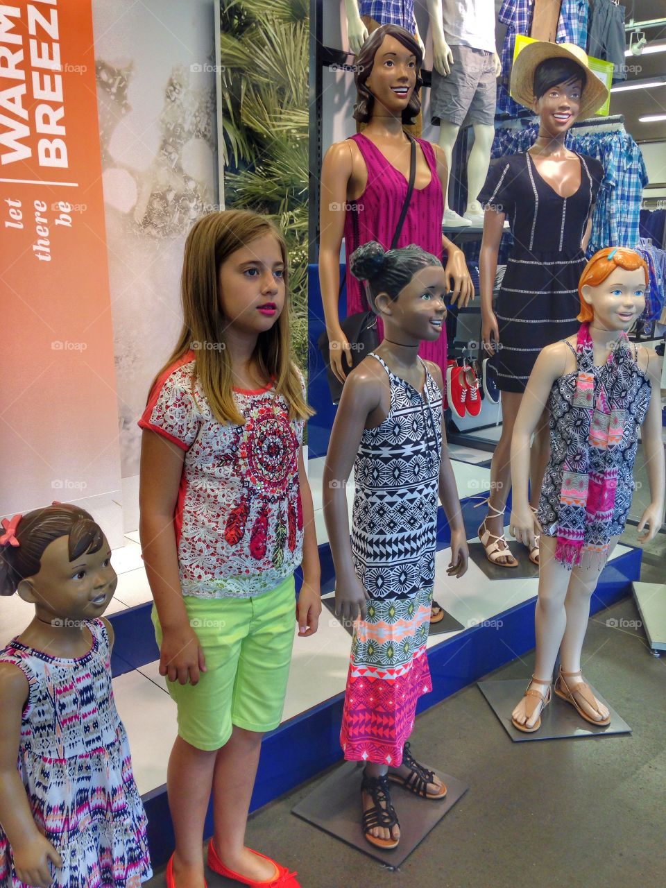 Real or make-believe?. Girl standing with mannequins