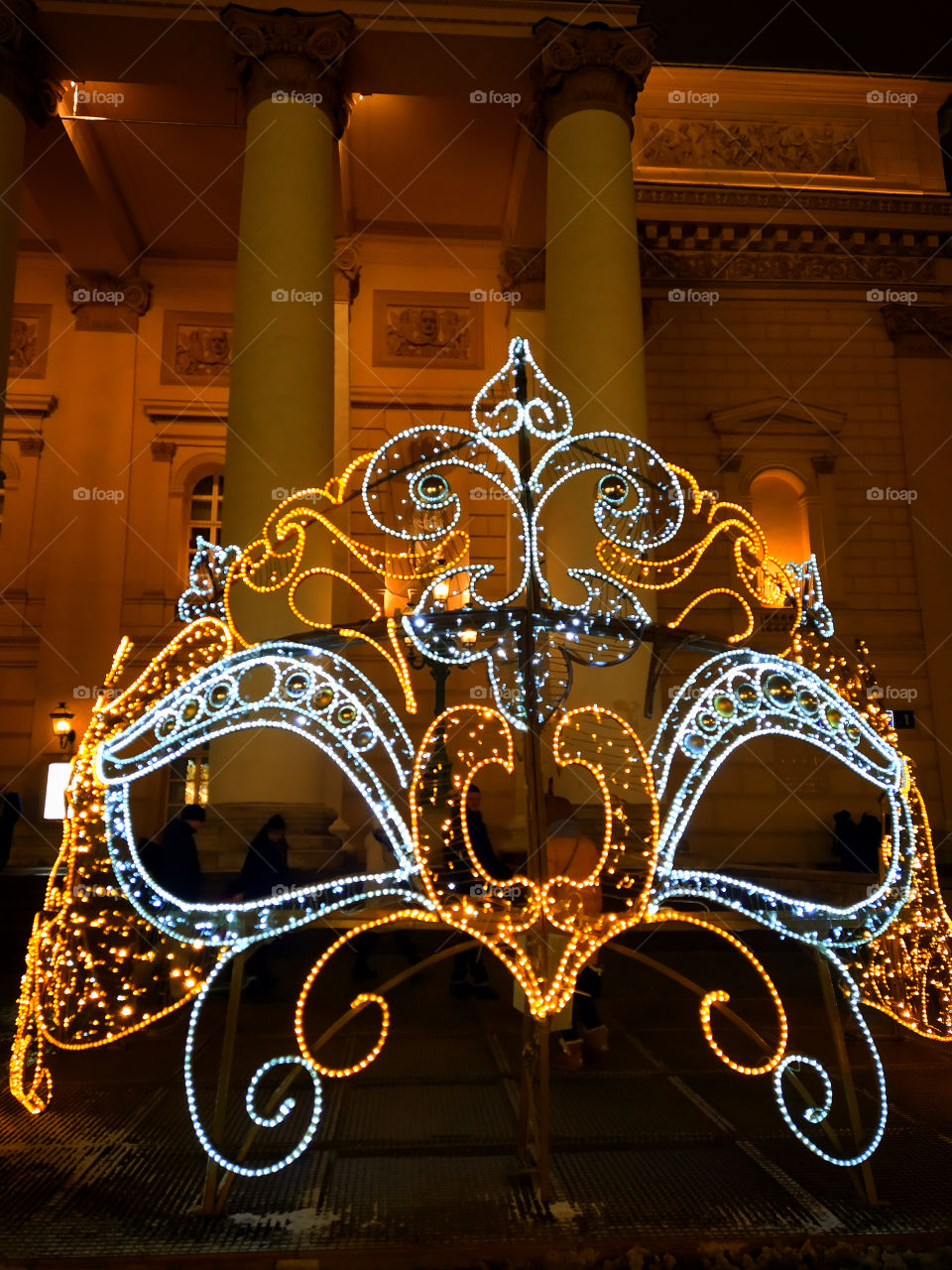 Moscow in the evening.  New Year street decorations.  A huge masquerade mask made of glowing garlands in front of the Bolshoi Theater